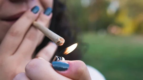 The young person smoking medical marijuana joint outdoors. The y — Stock Photo, Image