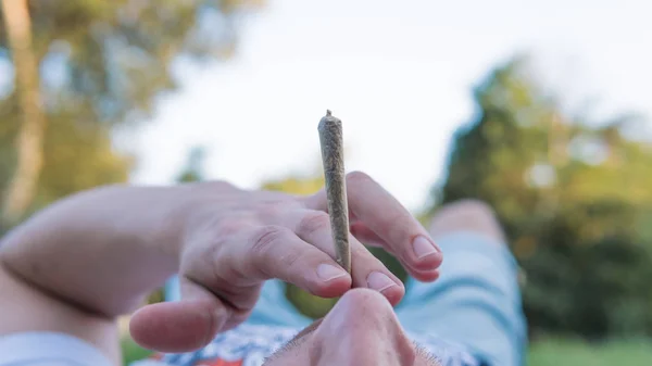 De jongere rook medische marihuana gewricht buitenshuis. De y — Stockfoto