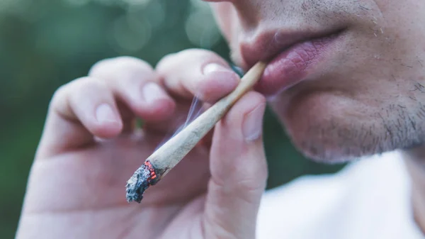 El joven que fuma marihuana medicinal al aire libre. La y —  Fotos de Stock