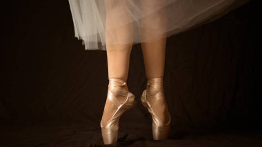 Beyaz noktalı balerinin dans eden bacaklarının yakın çekimi. 