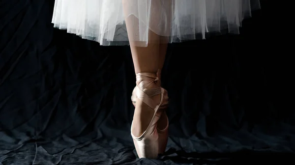 Close-up of dancing legs of ballerina wearing white pointe on a — Stock Photo, Image