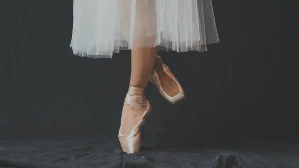 Primo piano delle gambe danzanti della ballerina che indossa una punta bianca su un — Foto Stock