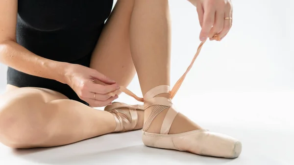 Close-up of beautiful legs of young ballerina who puts on pointe — Stock Photo, Image