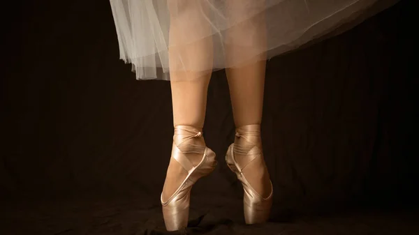 Close-up of dancing legs of ballerina wearing white pointe on a — Stock Photo, Image