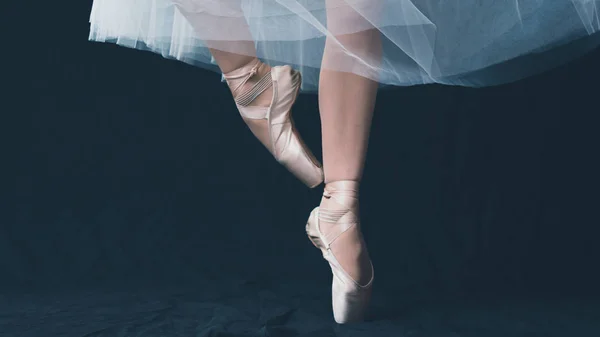 Close-up of dancing legs of ballerina wearing white pointe on a — Stock Photo, Image