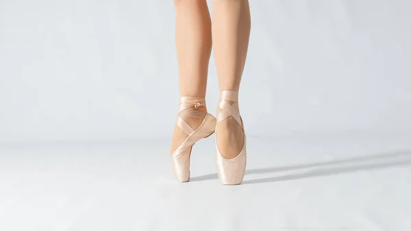Primer plano de las piernas de bailarina bailando con puntas blancas en un —  Fotos de Stock