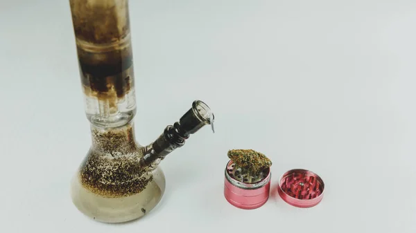 Крупним планом брудні бонги і м'ясорубки з медичними марихуани бутонами о — стокове фото