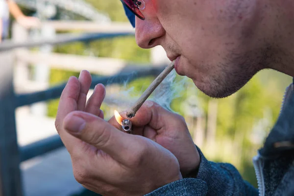 在户外吸食大麻的年轻人的特写镜头血红蛋白在男性手中变钝 大麻是一种草药和替代药物的概念 — 图库照片