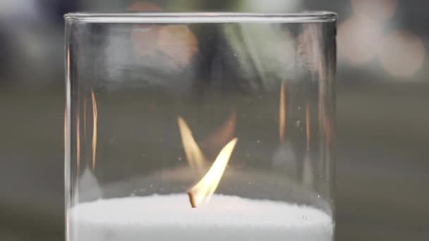 用透明的玻璃烛台把燃烧着的白色蜡烛拍成特写 慢动作婚礼装饰的概念 — 图库视频影像