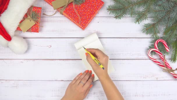 Flache Weibliche Handschrift Auf Der Liste Weihnachtsdekoration Herum Hölzerner Hintergrund — Stockvideo