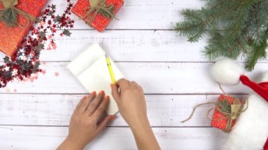 Noel Baba 'ya el yazısı yazan, Noel süsü veren, ahşap bir geçmişi olan bir kadın. Yeni yıl hayalleri ve dilekleri.