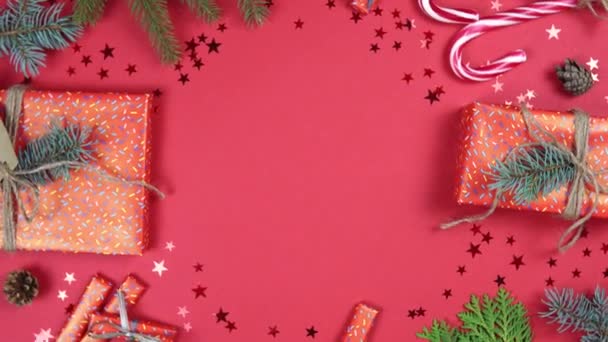 Vánoční pozadí 360 stupňů rotace. Jedlové větve, dárková krabice a konfety hvězda rotující na červeném pozadí. Koncept Nového roku dárky, slavnostní a sváteční nákupy