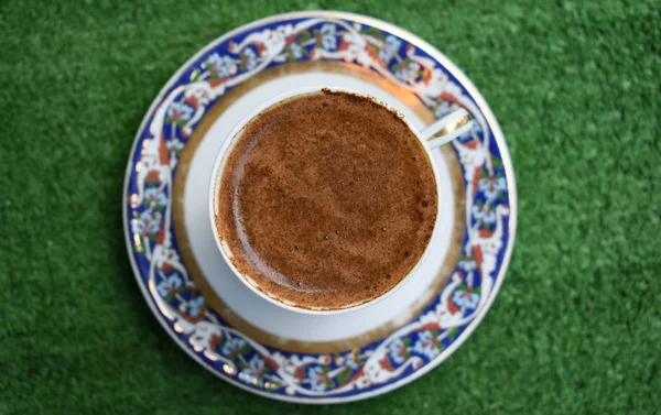 Turkish coffee, on green background. embroidered porcelain cup