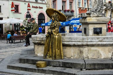 Lviv, market veya rynok meydanı / Ukrayna - 08 08 2019 : İnsanlar altın boya ile boyanmış. Canlı altın bir kız heykeli
