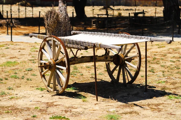 An old covered wagon wheel.Traditional wooden tumbrel