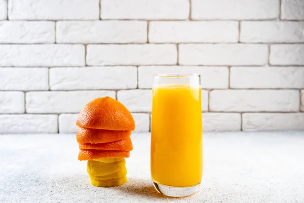 Beyaz masaya taze portakal ve limon suyu. Ev yapımı narenciye suyu. Sağlıklı gıda, beslenme ve antioksidan kavramı