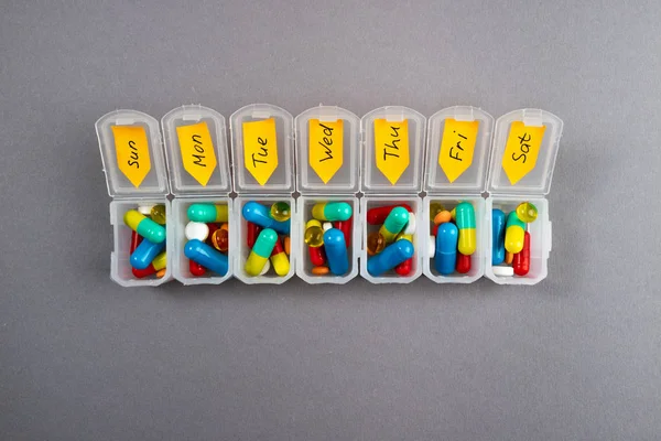 Haftalık Ajanda gri arka plan üzerinde haplarla. İlaç tıp tablet, kapsül ve hap kutusu