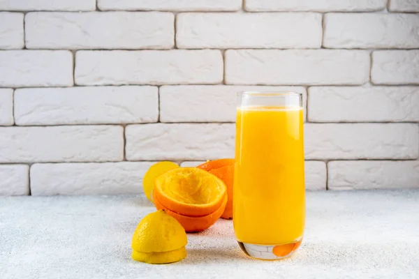 Beyaz masaya taze portakal ve limon suyu. Ev yapımı narenciye suyu. Sağlıklı gıda, beslenme ve antioksidan kavramı