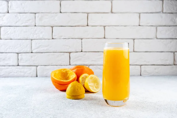 Beyaz masaya taze portakal ve limon suyu. Ev yapımı narenciye suyu. Sağlıklı gıda, beslenme ve antioksidan kavramı