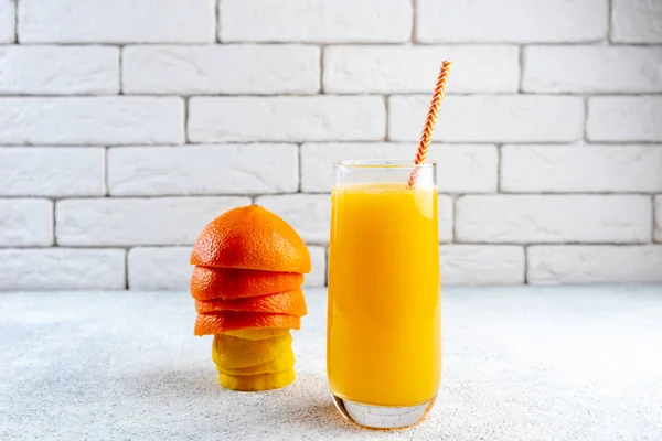 Beyaz masaya taze portakal ve limon suyu. Ev yapımı narenciye suyu. Sağlıklı gıda, beslenme ve antioksidan kavramı