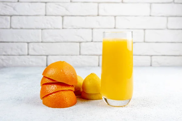 Beyaz masaya taze portakal ve limon suyu. Ev yapımı narenciye suyu. Sağlıklı gıda, beslenme ve antioksidan kavramı