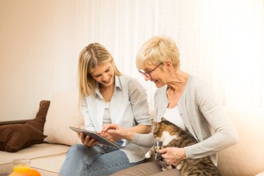 Anne, kız ve kedi, hoş bir ortamda, internetten kedi maması sipariş edin..