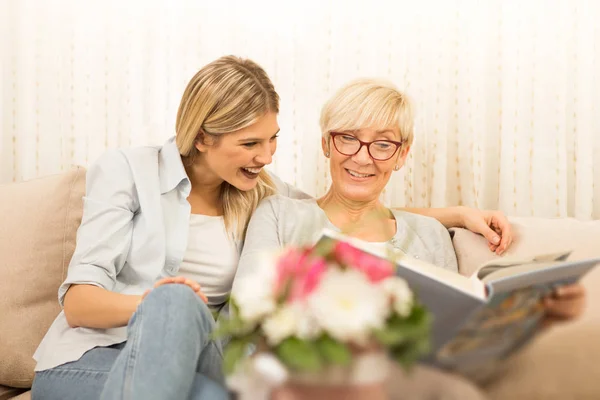 Anne ve kızı bir aile albümü izliyor, güzel anları hatırlıyorlar..