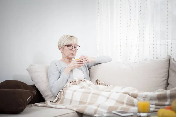 middle-aged woman is sad, sick and alone. There is nobody to help her. she is sick.