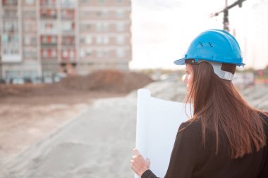 İnşaat alanındaki peyzaj kadın mimarı projenin nasıl gerçekleştirileceğini izliyor..