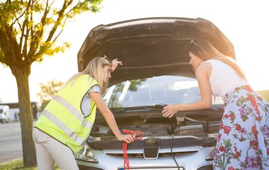 İki güzel genç kadın, şehirden uzaktaki yolda bozulmuş bir arabayı tamir etmeye çalışıyor..