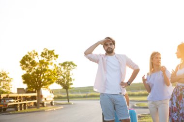 İki güzel arkadaşı olan yakışıklı bir genç adam ulaşımı bekliyor..