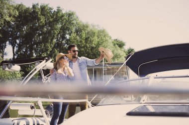 Yakışıklı sakallı genç sarışın kız arkadaşı sürat teknesi ile nereye gittiklerini gösterir.