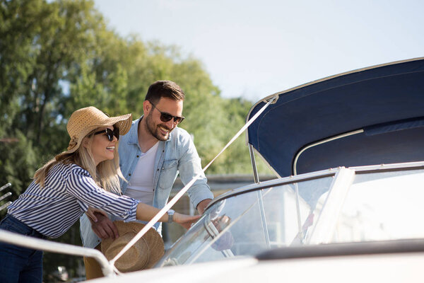 A beautiful young couple watches a motor boat that they intend to buy.