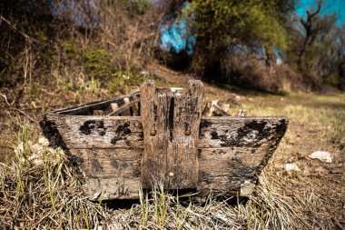 Kıyıdaki eski ahşap bir tekne, tekne çürümüş ve artık kullanılmıyor, ve içinde ve çevresinde bir sürü çöp var, plastik şişeler, plastik torbalar ve ambalajlar atıldı..