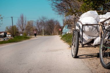 Çöplüklerden toplanan ve geri dönüşüme hazır atık ve ikincil hammaddeler içeren malların taşınması için üç tekerlekli bisiklet.