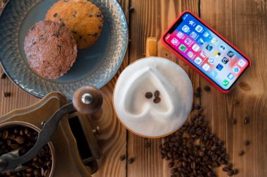 Taze kahve kahve çekirdekleri ahşap bir masa üzerinde ile smartphone ile