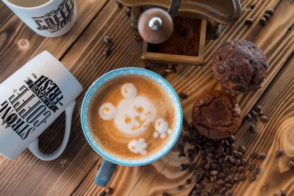 Vecchio macinino da caffè e tazza di caffè con chicchi di caffè sparsi e biscotti su sfondo di legno — Foto Stock