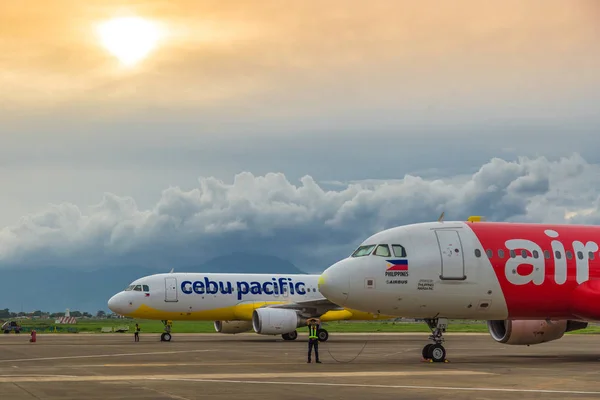 Düşük hava yolları Puerta Princesa Palawan Adası, Filipinler havaalanında, renkli günbatımında Cebu Pasifik ve Air Asia uçak maliyetli. Ağustos 2018.