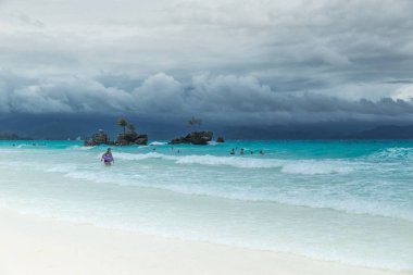 Beyaz Beach Boracay ve insanlar Grotto Willys üzerine Meryem Ana heykeli standları Rock yakınındaki bulutlu bir günde turkuaz masmavi denizde yüzmek. Boracay, Filipinler