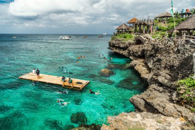 Grup Çinli turistler Crystal Cove adanın kayalık sahil hakkında turkuaz denizde dalış Boracay, Filipinler yakınındaki. Ağustos 2018