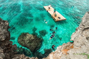Grup Çinli turistler Crystal Cove adanın kayalık sahil hakkında turkuaz denizde dalış Boracay, Filipinler yakınındaki. Ağustos 2018