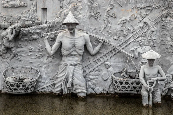 Национальный памятник - статуи в стенах Мемориальной башни в центре площади Мердека, Джакарта. Символизирует борьбу рабочих за Индонезию. Джакарта, Индонезия - июнь 2018 года — стоковое фото