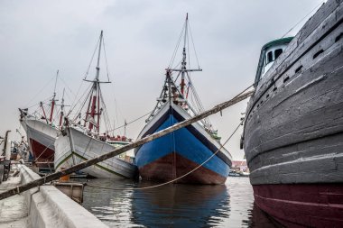 White and color ships in port Sunda Kelapa, Jakarta. Jawa, Indonesia clipart