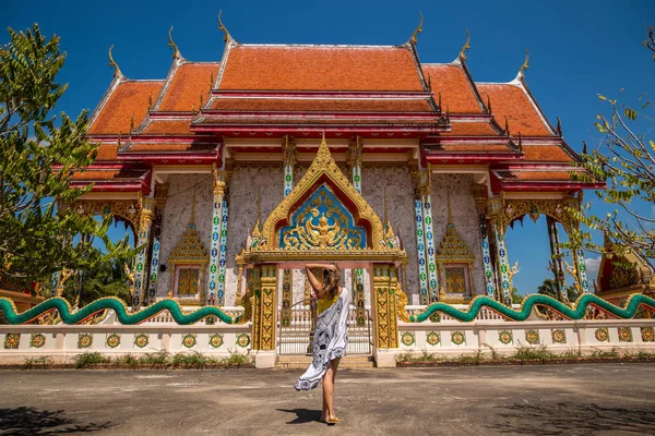 Женщины-туристы стоят спиной к храму Ват Кеу Мани Си Махато в солнечный день в Пханг Нга, Таиланд — стоковое фото