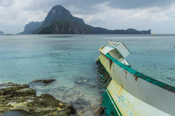 Broken fishing boat stranded after typhoon in rainy weather in El Nido, Palawan, Philippines