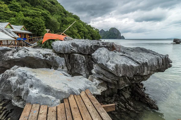 Rotsachtige stenen staan in de ondiepe zee op een bewolkte dag — Stockfoto
