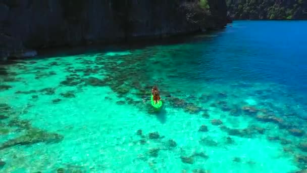 Muhteşem kayalar ve tropikal mercan resifi lagünü üzerinde uçan havadan görünümü. Erkek ve kadın Kayak denize açılıyor. Coron, Busuanga, Filipinler - Şubat 2018. — Stok video