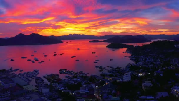 Beautiful red sunset in the sea harbor with moored yachts. Sunset over the sea pier with yachts and boats. Aerial view 4K — Stock Video