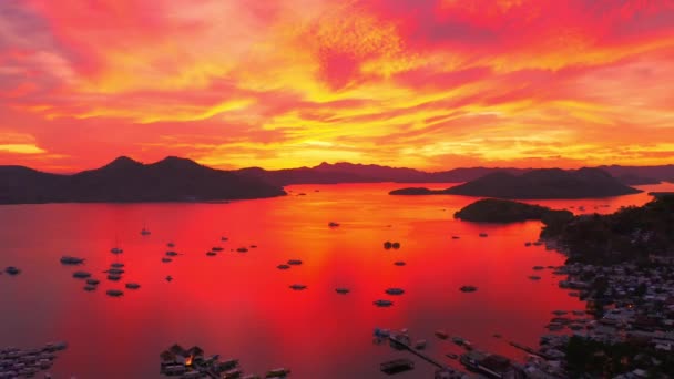 Vacker röd solnedgång i Havshamnen med förtöjda yachter. Solnedgång över havsbryggan med yachter och båtar. Satellitvy 4K — Stockvideo