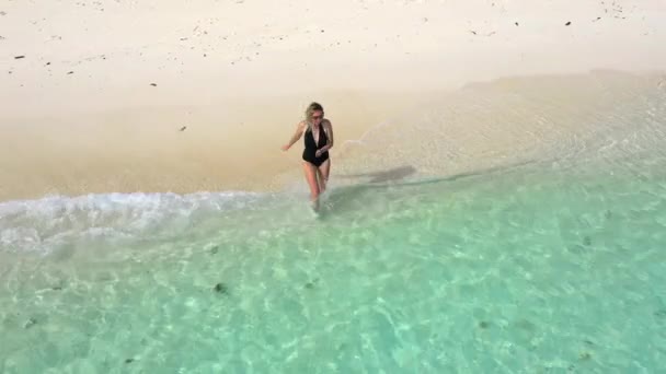 Feliz útero joven corre hacia el mar azul con salpicaduras en la isla tropical. Coron, Palawan, Filipinas. Vista aérea en cámara lenta 4K — Vídeos de Stock
